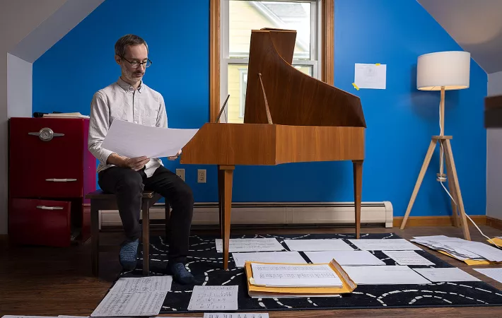 Eric Wubbels sitzt neben einem Klavier
